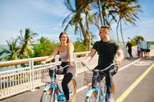 un homme et une femme à vélo sur un pont dans l'établissement Faro Blanco Resort & Yacht Club, à Marathon