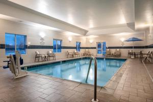 una piscina en un hotel con mesas y sillas en Holiday Inn Express and Suites Edwardsville, an IHG Hotel, en Edwardsville