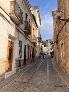 une rue vide dans une vieille ville avec des bâtiments dans l'établissement Sagunto Castillo 17, à Sagonte