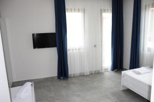 Schlafzimmer mit blauen Vorhängen und einem TV an der Wand in der Unterkunft La Sorella Butik Hotel in Ortaca