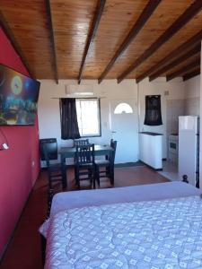 1 dormitorio con 1 cama, mesa y sillas en Galeano Aparts en Santa Rosa