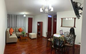 a woman sitting at a desk in a living room at Departamento Privado in Lima