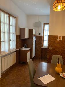 a kitchen with a table with chairs and a refrigerator at Appartamento VILLAMARE in Numana +4 photos