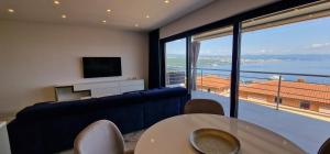 een woonkamer met een blauwe bank en een groot raam bij Apartment Eclipse in Opatija