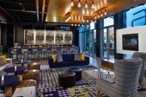 a lobby with couches and tables and a bar at Aloft Dulles Airport North in Ashburn