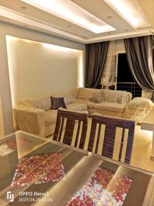 un salon avec un canapé et deux chaises dans l'établissement شقة رائعة قريبة من الاهرامات بالجيزة داخل كومبوند خاص, à ‘Ezbet `Abd el-Ḥamîd