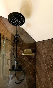 a shower in a bathroom with a black shower head at Odli Glamping - Deri in Welshpool