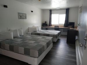 Postel nebo postele na pokoji v ubytování Cardston Inn