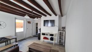 ein Wohnzimmer mit weißen Wänden und Holzdecken in der Unterkunft Petite maison cosy wifi avec terrasse in Montigny-le-Gannelon