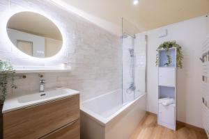 a white bathroom with a sink and a shower at Idéal Famille: Jardin, Proche Commerces & Plage in Bray-Dunes +18 photos