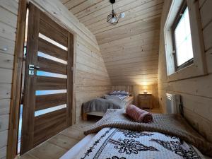 1 Schlafzimmer mit 2 Betten in einer Holzhütte in der Unterkunft Śtyry Pory Roku in Bór Leśnica