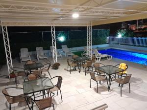 un patio con mesas y sillas junto a una piscina en Villa Swan, en Bar