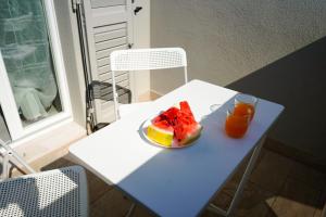 un piatto di frutta e un bicchiere di succo d'arancia su un tavolo di Penelope a Porto SantʼElpidio