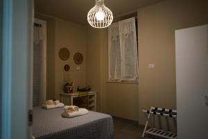 una camera con due letti e un lampadario a braccio di Penelope a Porto SantʼElpidio