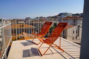 2 sedie arancioni sedute sopra un balcone di Penelope a Porto SantʼElpidio