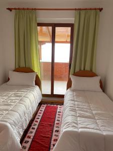 twee bedden in een kamer met een raam bij Vila 8 Kruje in Krujë