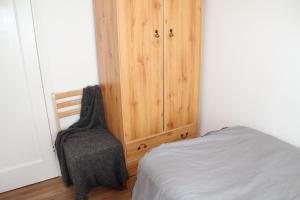 1 dormitorio con 1 cama y armario de madera en Cozy light single bedroom, en Edgware