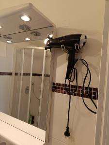 Ein Haartrockner ist mit einem Badezimmerspiegel verbunden. in der Unterkunft Moderne und schöne Wohnung in Graz
