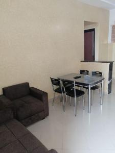 uma sala de estar com um sofá, uma mesa e cadeiras em Appartement comfortable avec vue mer direct em Sidi Ifni