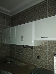uma cozinha com armários brancos e um lavatório em Appartement comfortable avec vue mer direct em Sidi Ifni