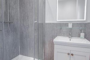 a bathroom with a shower and a sink and a mirror at The Barn in Longhope - Luxury Barn Conversion in Longhope