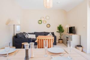 a living room with a table and a couch at The Barn in Longhope - Luxury Barn Conversion in Longhope