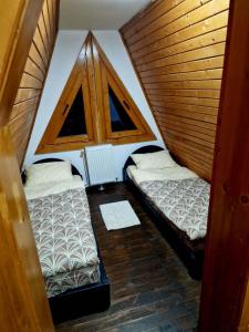 um pequeno quarto com 2 camas e uma janela em Bunloc House em Brasov