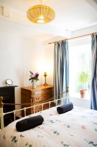 1 dormitorio con 1 cama con 2 almohadas en Lovely cottage with private garden, en Penryn