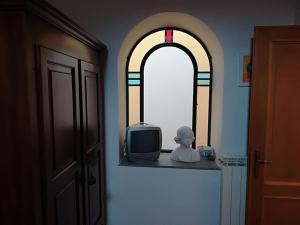 una ventana con una pequeña TV y una estatua en una habitación en A Casa di Martina, en Montefiascone