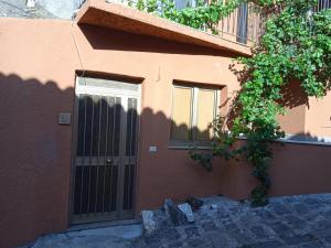 a building with a door and a tree in front of it at CASA DI NONNA in Forza dʼAgro