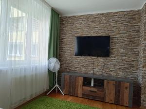 salon z telewizorem na murze z cegły w obiekcie Moderne und schöne Wohnung w Grazu