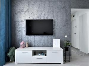 a living room with a tv on a wall at Inga Apartment in Turda