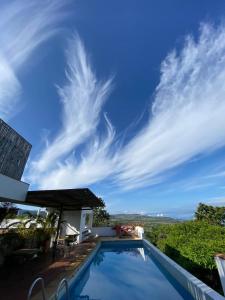 a villa with a swimming pool and a blue sky at Hotel Alto Del Viento in Barichara