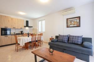 a living room with a blue couch and a table at Villa Stone House with Pool in Nin