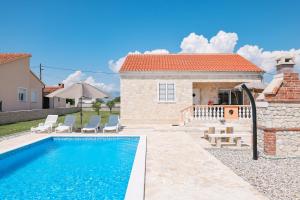 a villa with a swimming pool in front of a house at Villa Stone House with Pool in Nin