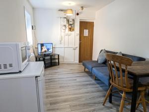 a living room with a couch and a table with a microwave at Cozy Central Apartments - with Private Kitchens & Bathrooms in Portsmouth