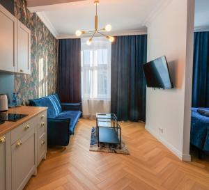 een woonkamer met een blauwe bank en een tv bij Apartament Zwycięzców 2 in Stargard