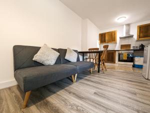 un soggiorno con divano e una cucina di Cozy Central Apartments - with Private Kitchens & Bathrooms a Portsmouth
