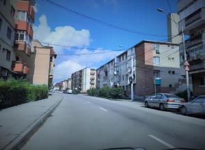 an empty street with buildings and cars parked on it at Inga Apartment in Turda