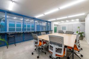 un ufficio con pareti blu e tavolo e sedie di Duque 1705 by LikeHome a Porto Alegre