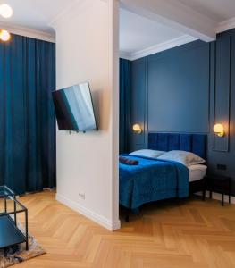 een slaapkamer met een bed en een flatscreen-tv bij Apartament Zwycięzców 2 in Stargard