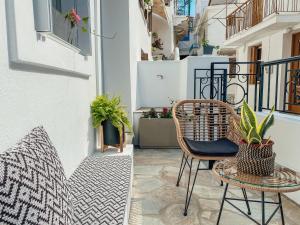 un balcón con sillas y plantas en un edificio en Evagelias suite en Skopelos Town