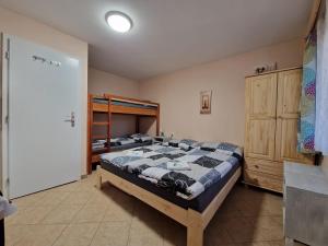 ein Schlafzimmer mit einem Bett und einem Etagenbett aus Holz in der Unterkunft Chatky U Davida Máchovo jezero in Doksy