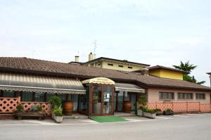 a building with an umbrella in front of it at Hotel Agriturismo Al Luogo Del Giulio in Maniago