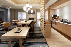 a restaurant with wooden tables and a kitchen at Fairfield Inn & Suites by Marriott Montreal Airport in Dorval
