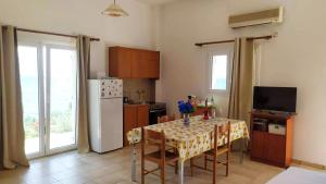 a kitchen with a table with chairs and a refrigerator at NIKOS & SPIROS in Trapezaki
