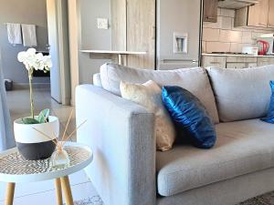 a living room with a couch and a table with pillows at Cozy Sparrow Hideaway in Sandton