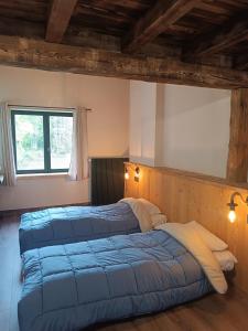 een slaapkamer met 2 bedden en een raam bij Les étoiles de Bevy Gîtes in Lajoux