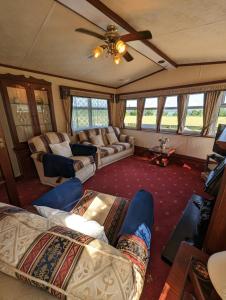 a living room with couches and a ceiling fan at The Lambourne in Dunoon