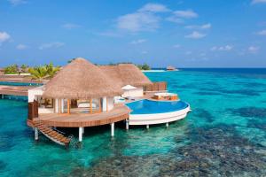 un complejo en el océano con un barco en el agua en W Maldives en Fesdu Island